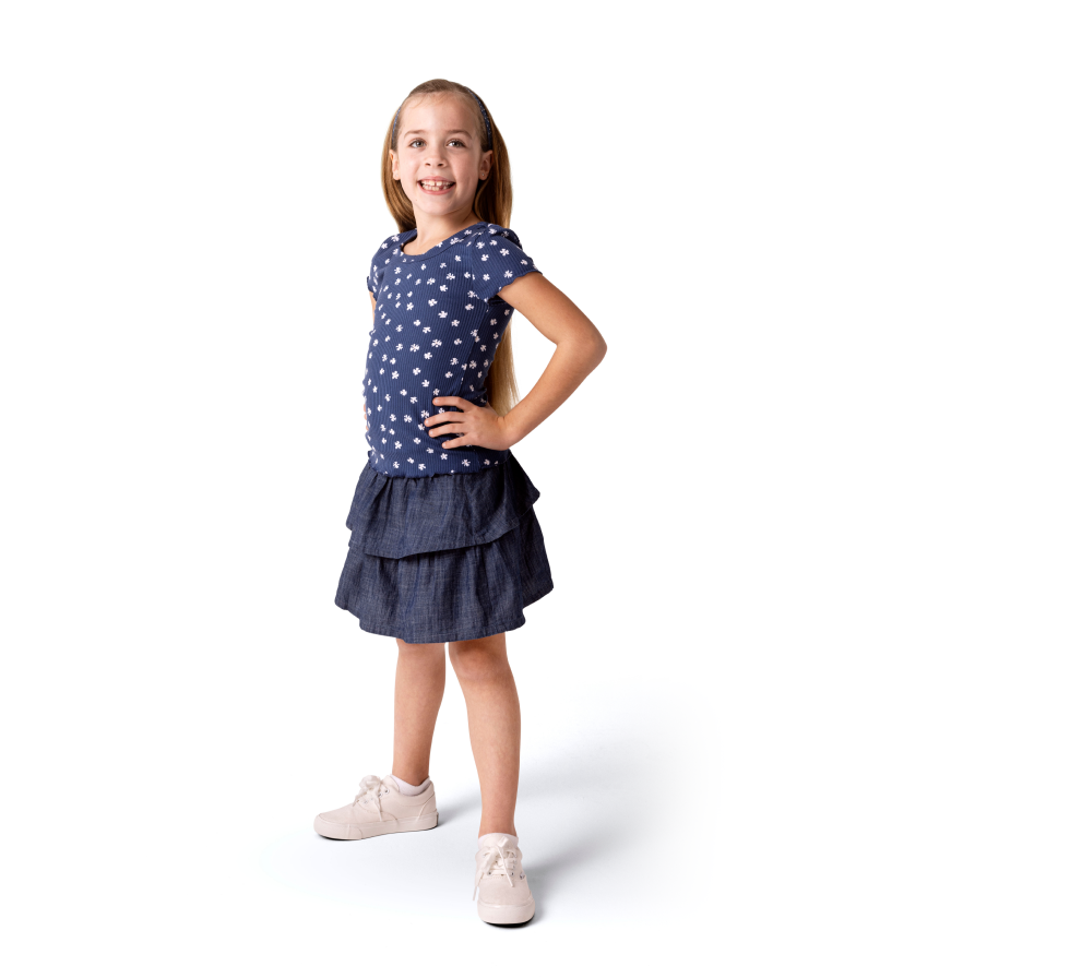 A young girl standing with her hands on her hips.