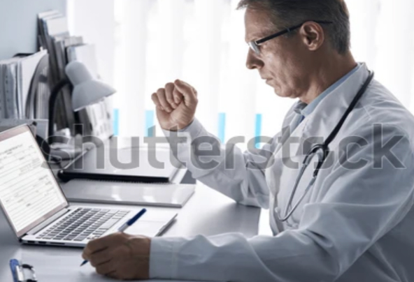 A doctor looking down at his laptop